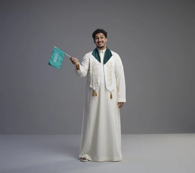 خريج سعودي يحتفل بالعلم الوطني في الاستوديو