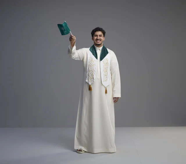 Saudi Male Graduate Holding National Flag in Studio