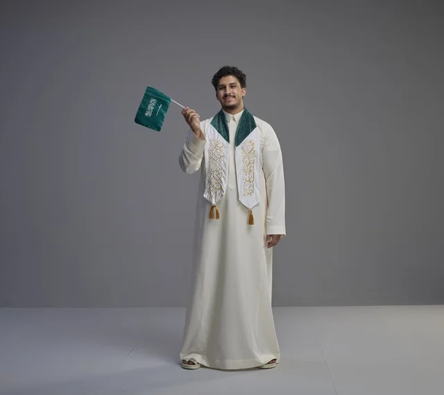 Saudi Male Graduate Holding National Flag Indoors