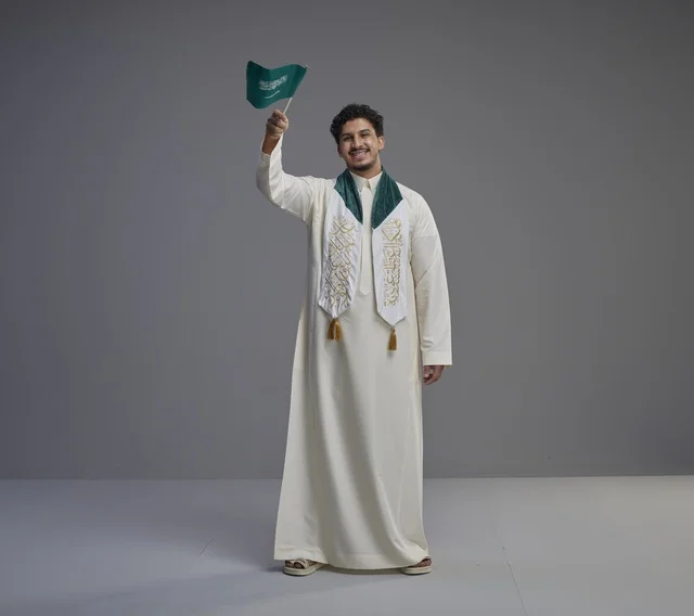 Saudi Graduate Holding National Flag in Studio Portrait