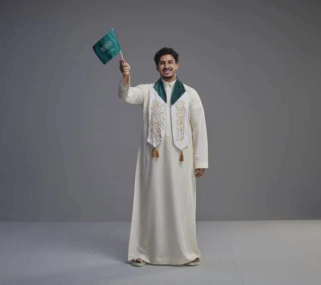 Saudi Graduate Holding National Flag in Studio
