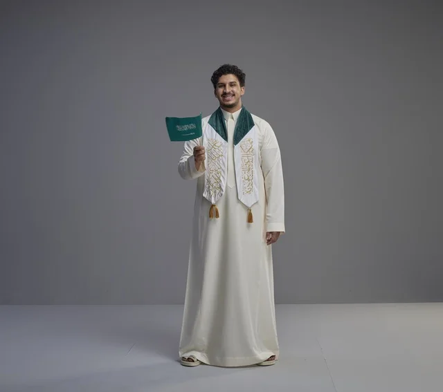 Saudi Graduate Holding Saudi National Flag in Gray Studio