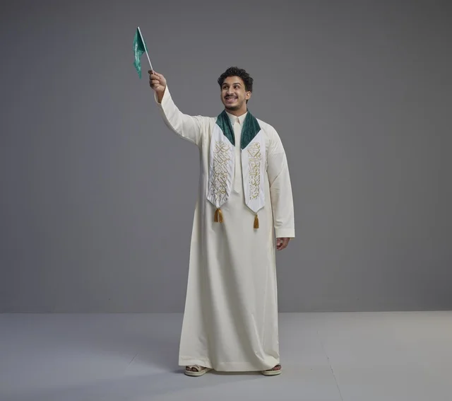 خريج سعودي يحمل العلم الوطني في الاستوديو