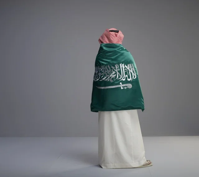 Saudi Man Wrapped in National Flag Standing in Studio