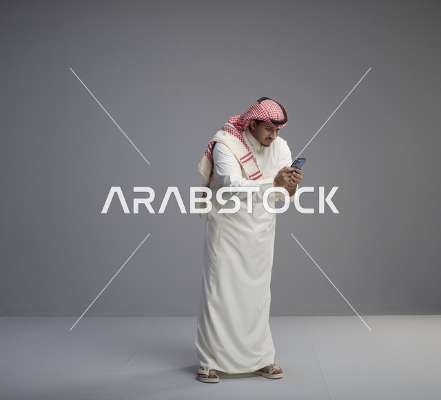 رجل سعودي يستخدم الهاتف الذكي في الاستوديو