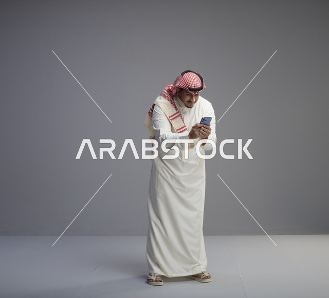 رجل سعودي يستخدم الهاتف الذكي في الاستوديو