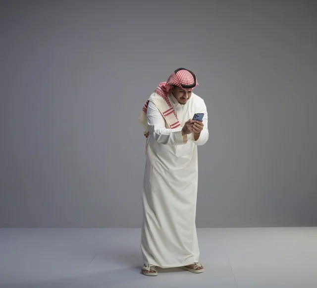 رجل سعودي يستخدم الهاتف الذكي في الاستوديو