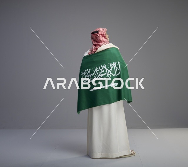 رجل سعودي يحمل العلم الوطني رؤية خلفية