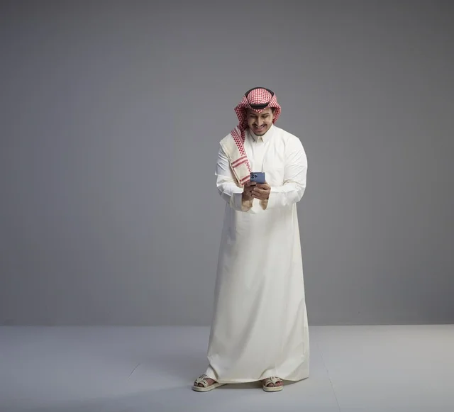 Saudi Man Using Smartphone in Traditional Thobe