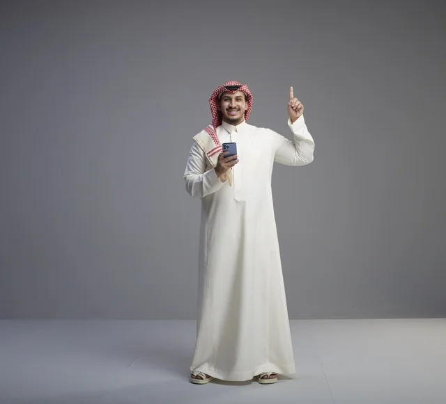 Saudi Man with Smartphone Pointing Up in Studio Shot