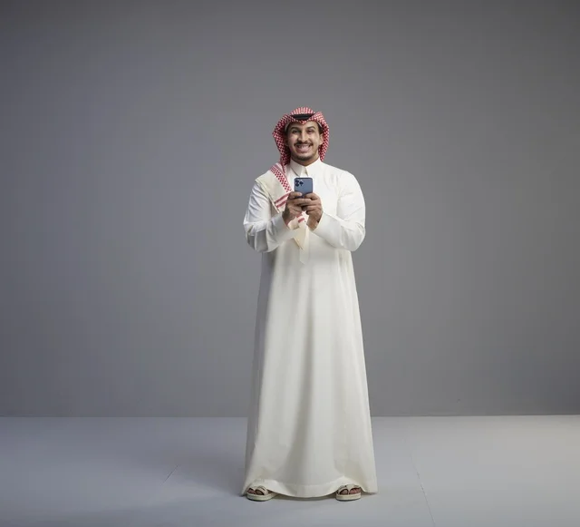 رجل سعودي يستخدم الهاتف الذكي في الاستوديو