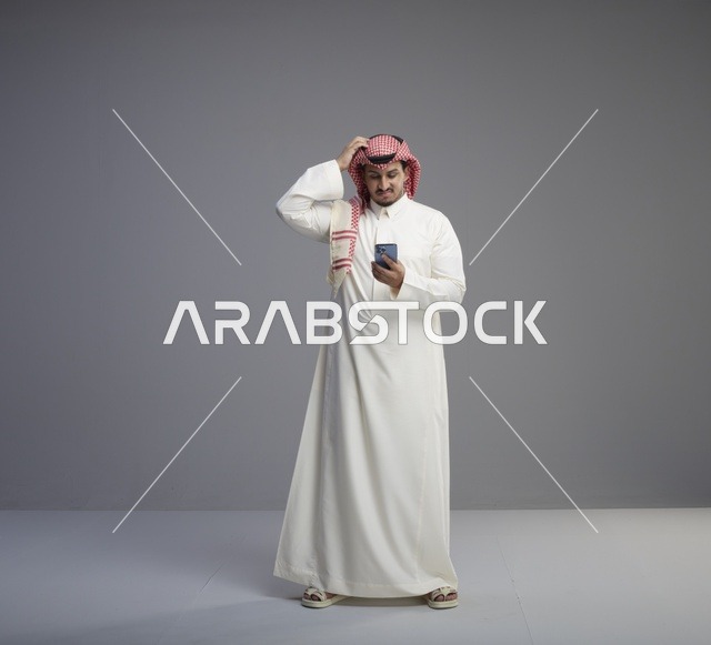 رجل سعودي يستخدم الهاتف الذكي في الاستوديو