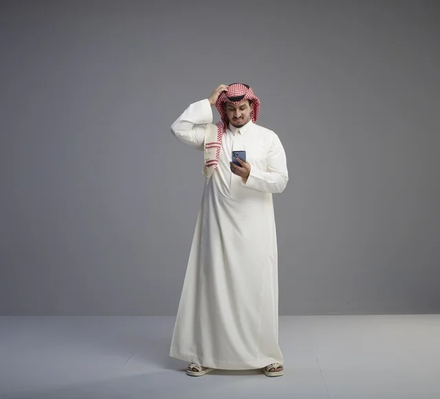 رجل سعودي يستخدم الهاتف الذكي في الاستوديو