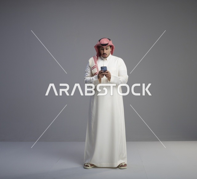 رجل سعودي يستخدم الهاتف الذكي في الاستوديو