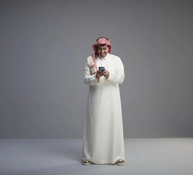 رجل سعودي يستخدم الهاتف الذكي في الاستوديو