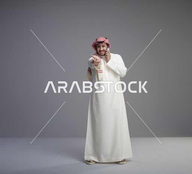 رجل سعودي يتحدث بالهاتف الذكي في الاستوديو