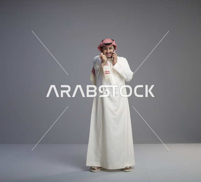 رجل سعودي يتحدث بالجوال بالزي التقليدي