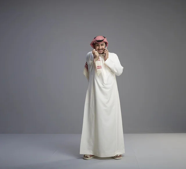 رجل سعودي يتحدث بالجوال بالزي التقليدي