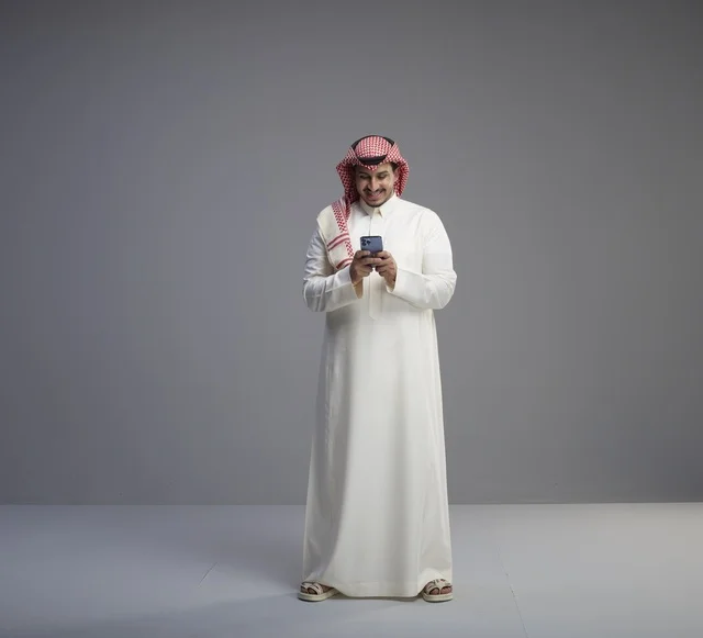 رجل سعودي يستخدم الهاتف الذكي للمراسلة