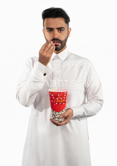 بورتريه لرجل عربي خليجي سعودي يحمل بيده علبة الفشار ، ايماءات الوجه واليدين تدل على الصدمة والدهشة ، مشاهدة الافلام داخل السينما ، متابعة افلام الاثارة والاكشن ، أفلام وسينما