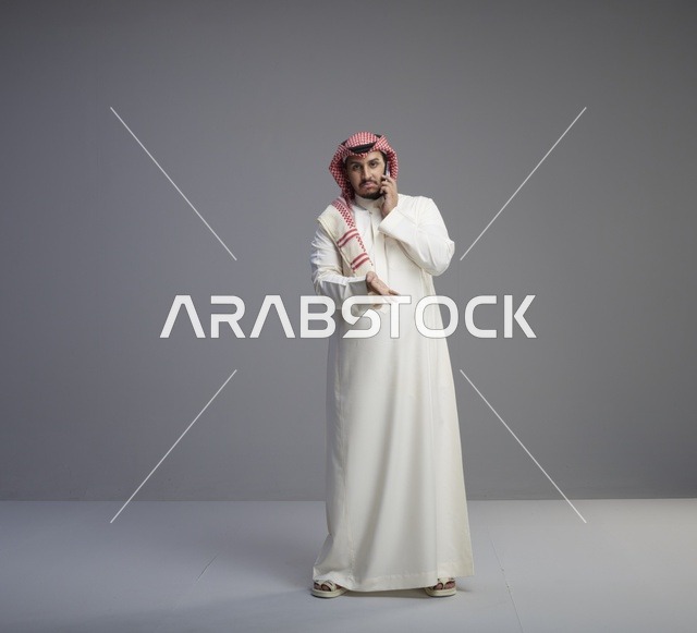 رجل سعودي يتحدث عبر الهاتف الذكي في الاستوديو