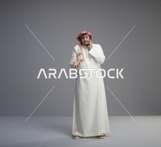 رجل سعودي يتحدث عبر الهاتف الذكي في الاستوديو