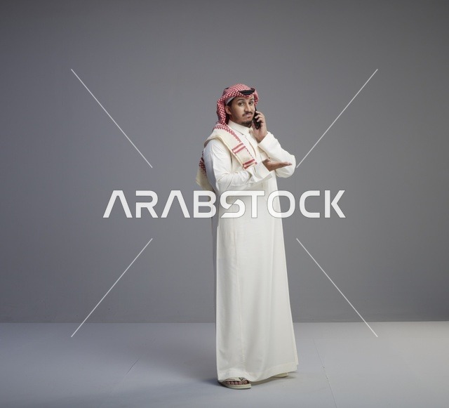 رجل سعودي يتحدث عبر الهاتف الذكي في الاستوديو