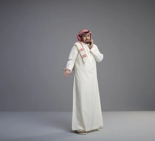 Saudi Man Talking on Smartphone in Traditional Thobe