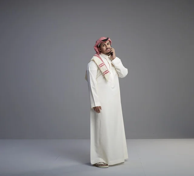 رجل سعودي يتحدث بالهاتف الذكي في الاستوديو