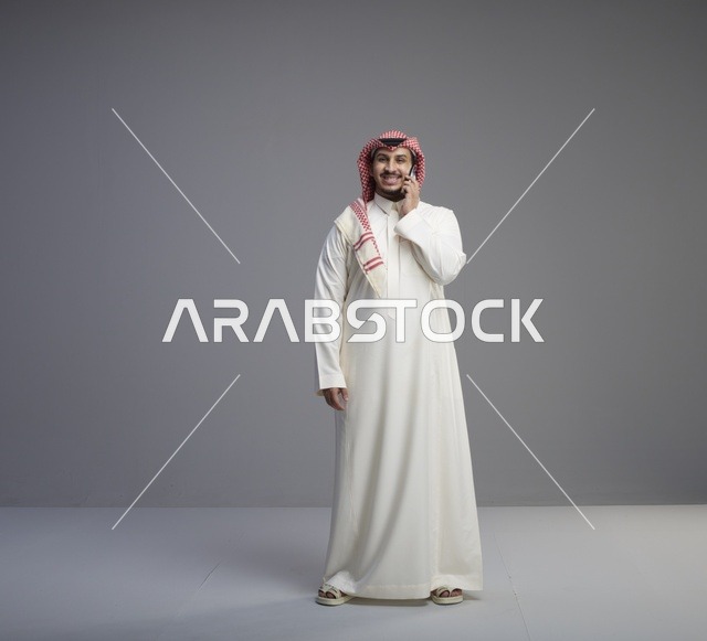 رجل سعودي يتحدث عبر الجوال بالزي التقليدي