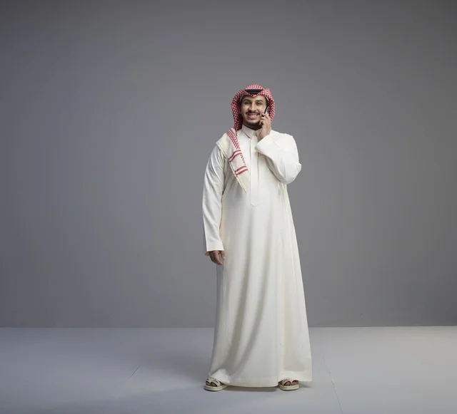 رجل سعودي يتحدث عبر الجوال بالزي التقليدي
