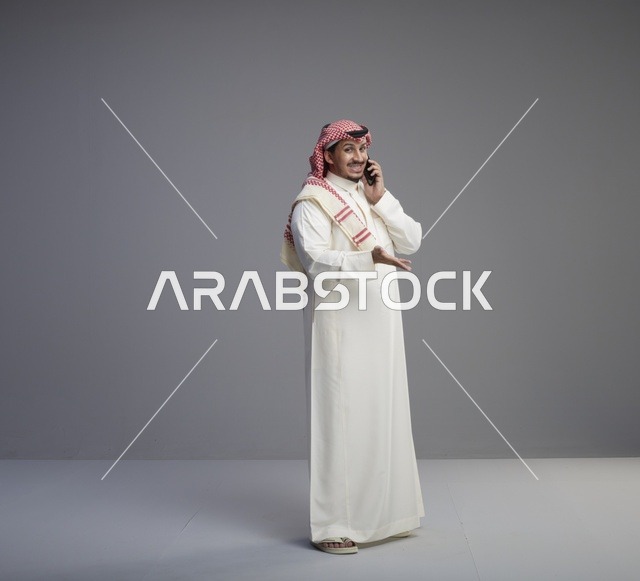 رجل سعودي يتحدث عبر الهاتف الذكي في الاستوديو