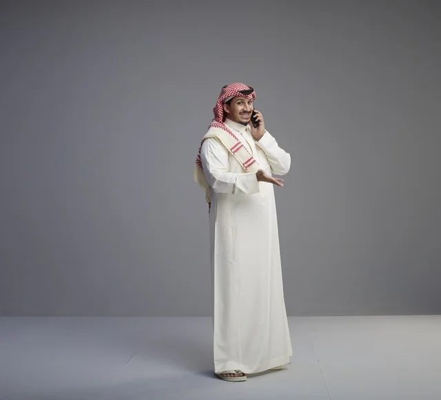 رجل سعودي يتحدث عبر الهاتف الذكي في الاستوديو