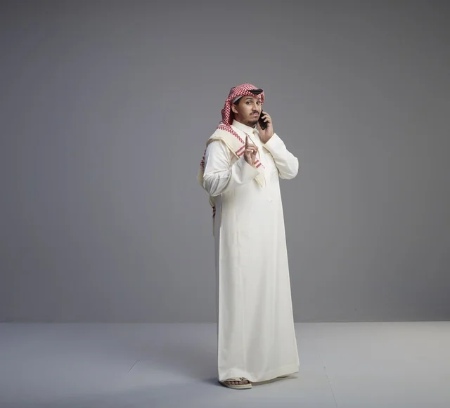 رجل سعودي يتحدث عبر الهاتف الذكي في استوديو