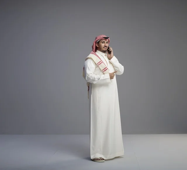رجل سعودي يتحدث بالجوال بالزي التقليدي