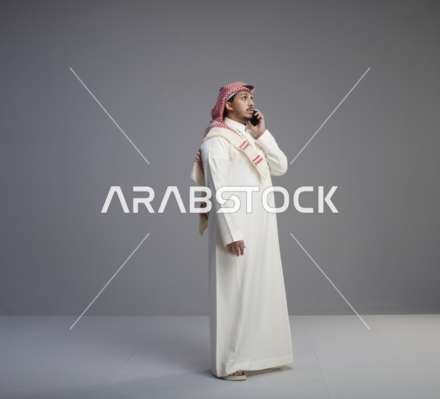 رجل سعودي يتحدث بالهاتف الذكي في استوديو