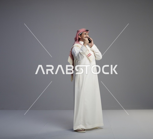 رجل سعودي يتحدث عبر الهاتف الذكي في الاستوديو