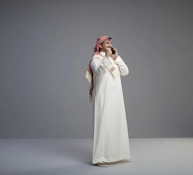 رجل سعودي يتحدث عبر الهاتف الذكي في الاستوديو