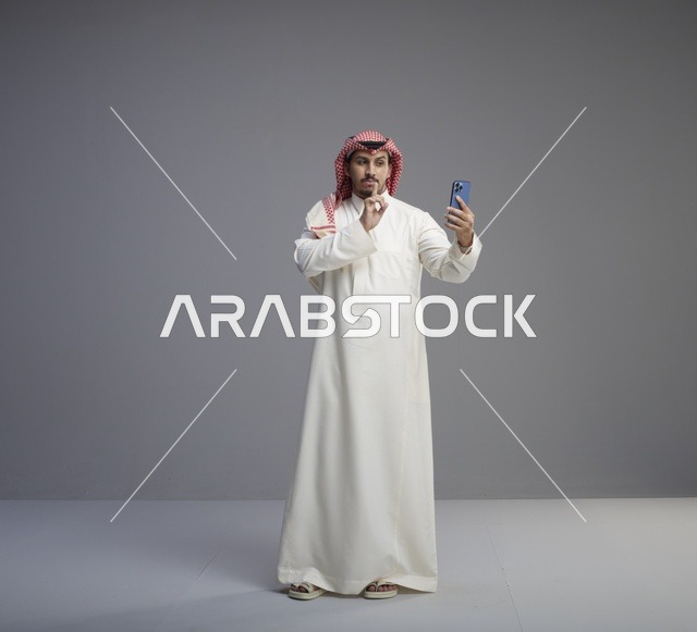 رجل سعودي يستخدم الجوال ويطلب الصمت