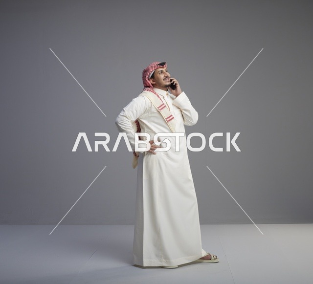 رجل سعودي يتحدث عبر الهاتف الذكي في الاستوديو