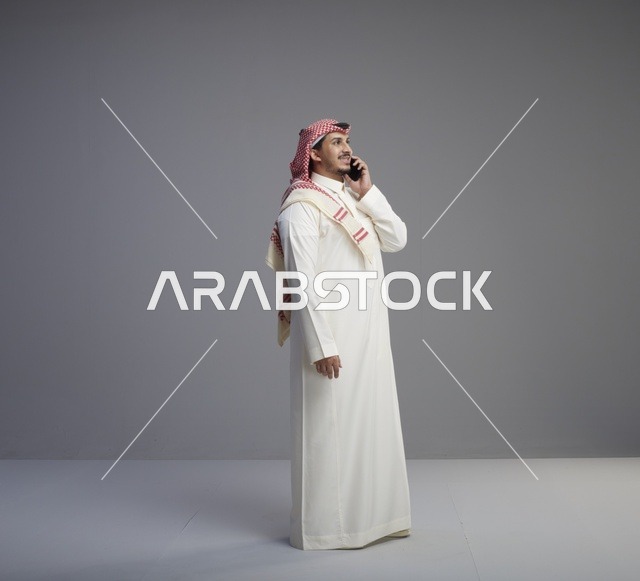 رجل سعودي يتحدث عبر الهاتف الذكي في الاستوديو