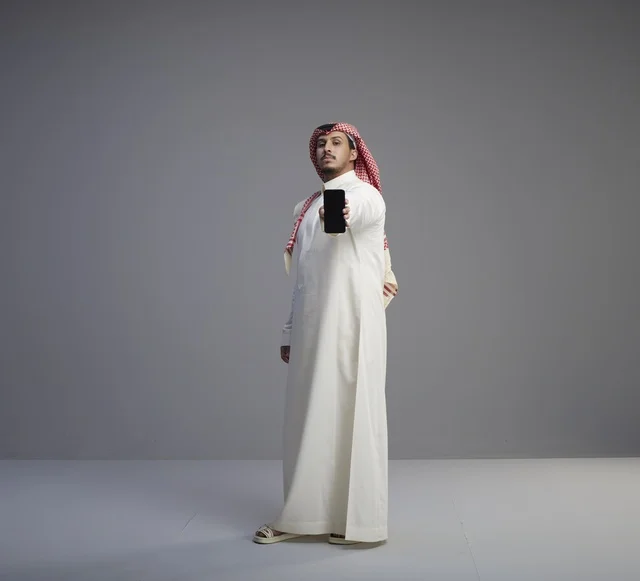 Saudi Man Holding Smartphone in Studio Full Shot
