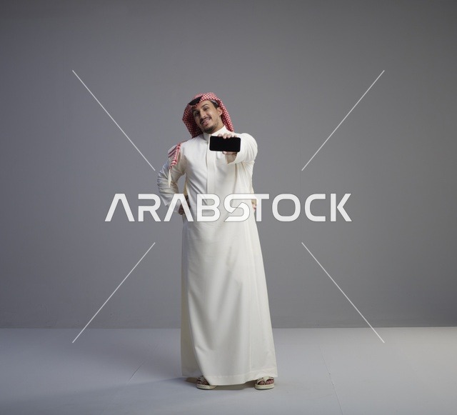 رجل سعودي يحمل نموذج هاتف ذكي بشاشة سوداء