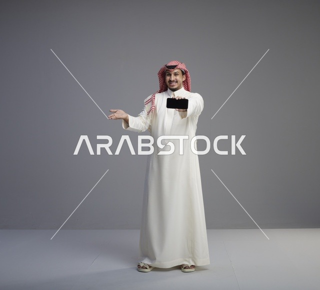 رجل سعودي يحمل هاتف ذكي بشاشة سوداء