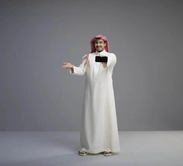 Saudi Man Holding Blank Smartphone in Studio