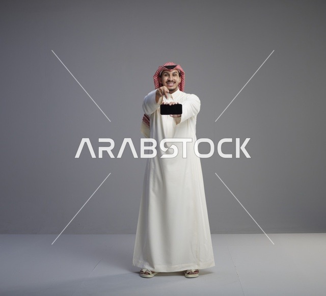 رجل سعودي يحمل نموذج هاتف ذكي أفقي