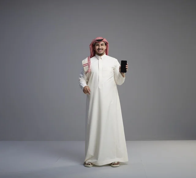 رجل سعودي يحمل هاتف ذكي بشاشة فارغة