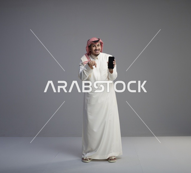 رجل سعودي يحمل هاتف ذكي بشاشة فارغة
