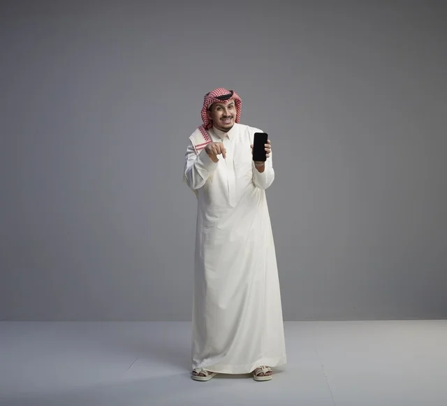 Saudi Man Holding Smartphone with Blank Screen