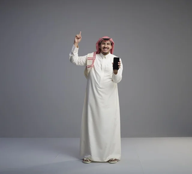 Saudi Man Holding Smartphone Pointing Upwards